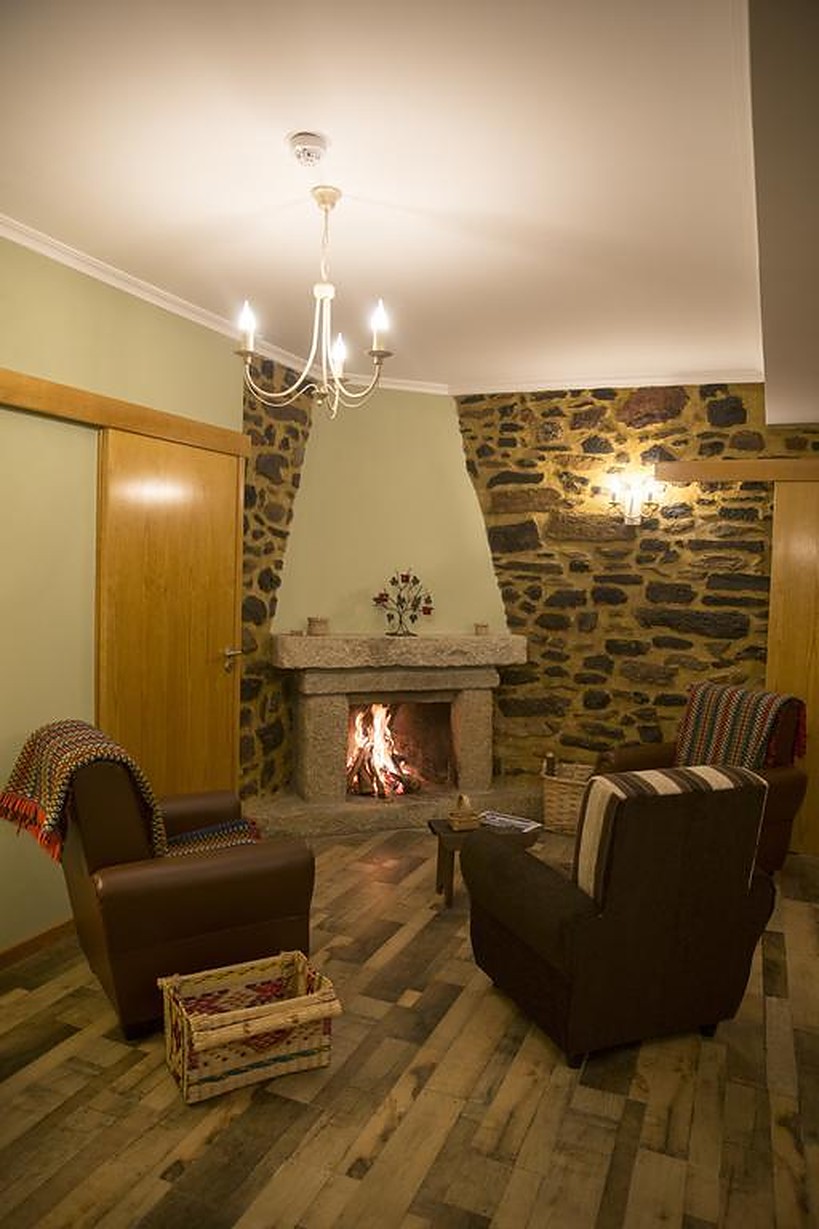 Sala de estar com lareira acesa, poltronas de couro e mantas de lã