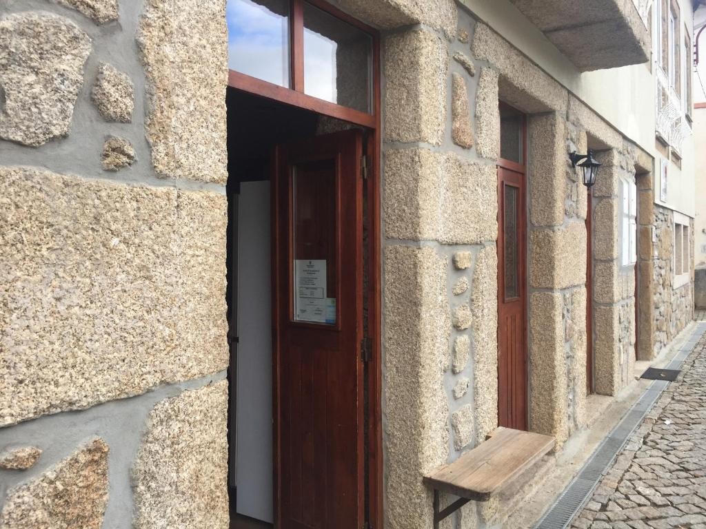 Fachada de granito das Casas do Terreiro, com portas de madeira, em Carragozela