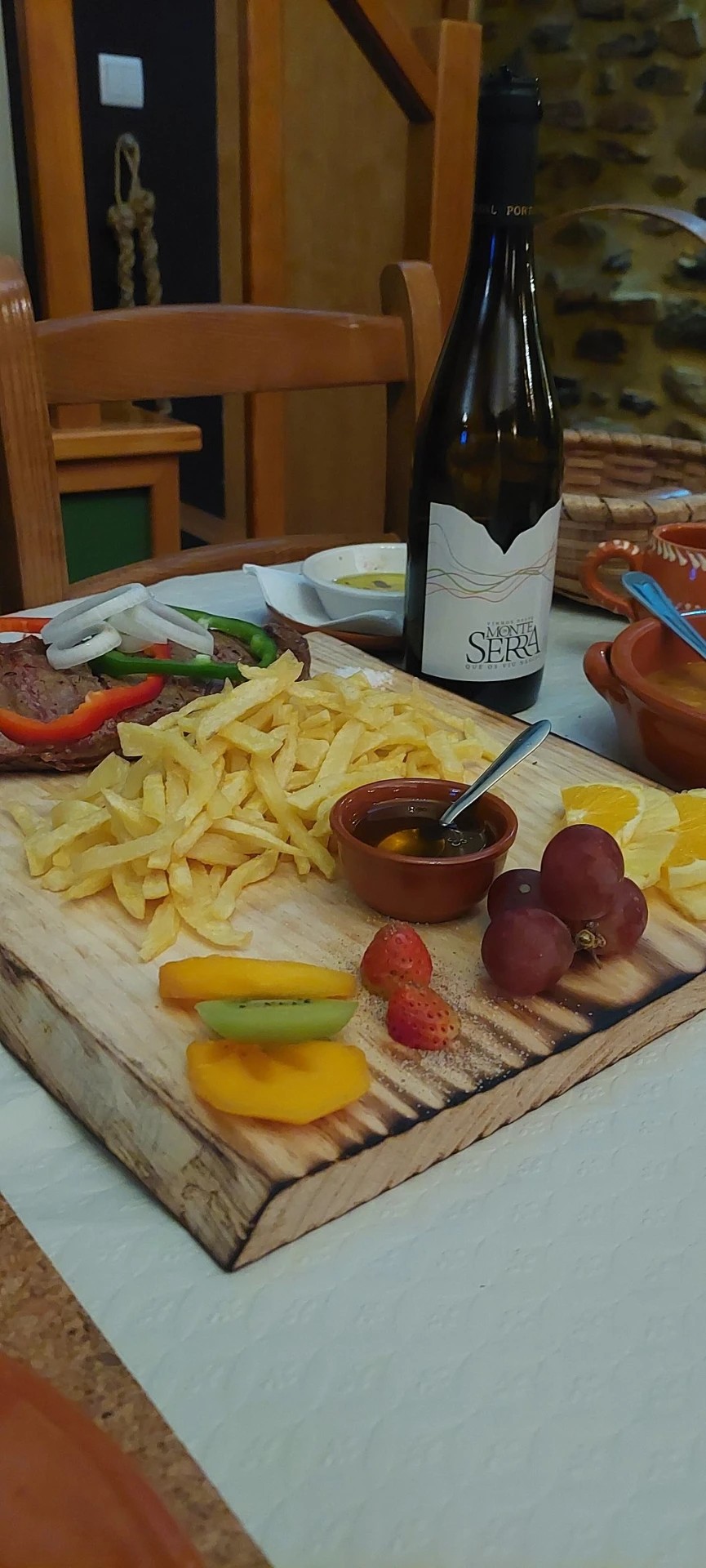 Tábua de carne com batatas fritas e fruta da época, servida com vinho do Dão